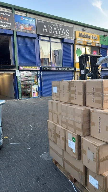 Stacked cardboard boxes beside a loading area outside shops
