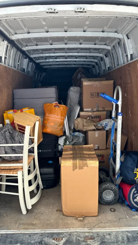 Chairs, boxes and household belongings packed inside a removal van