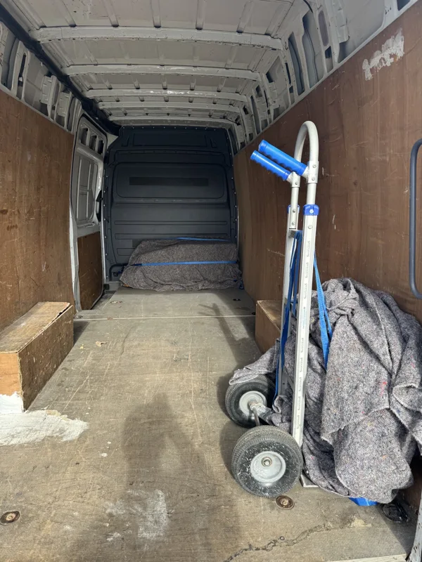 Clear van load space with a moving trolley and protective blanket
